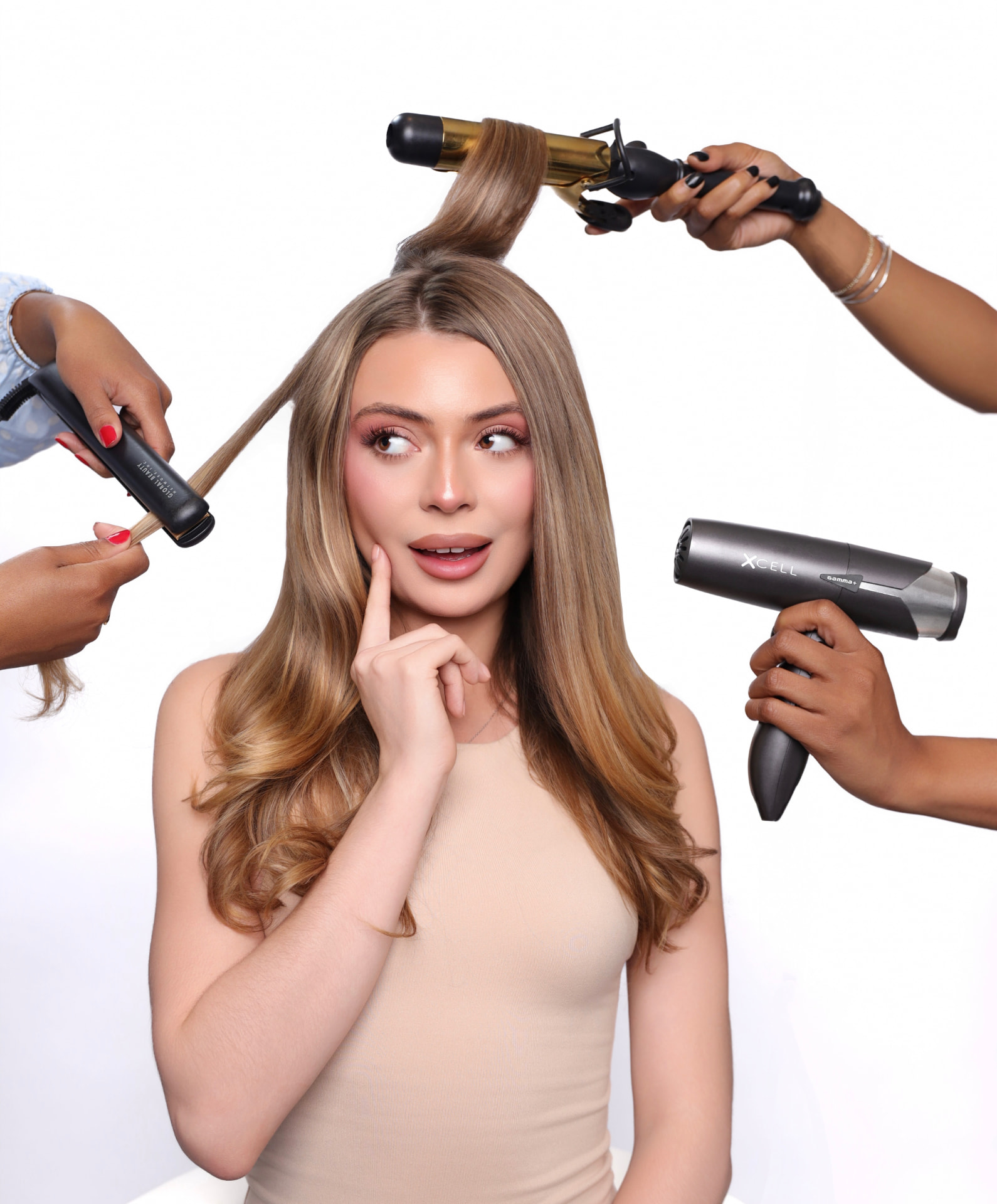 Blonde model surrounded by stylists' tools — curling iron, flat iron, and blow dryer
