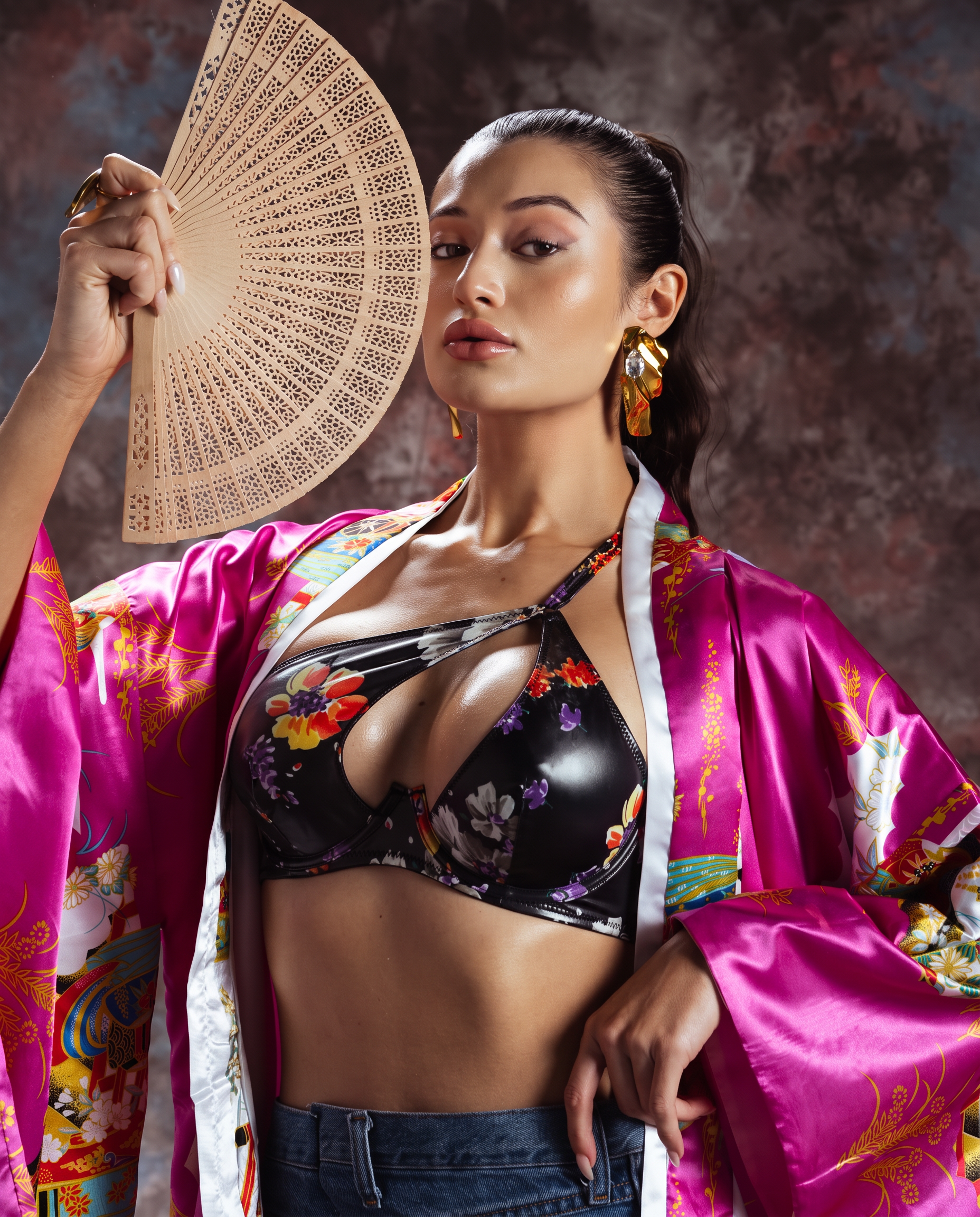 Beauty model with a sleek ponytail holding a decorative fan