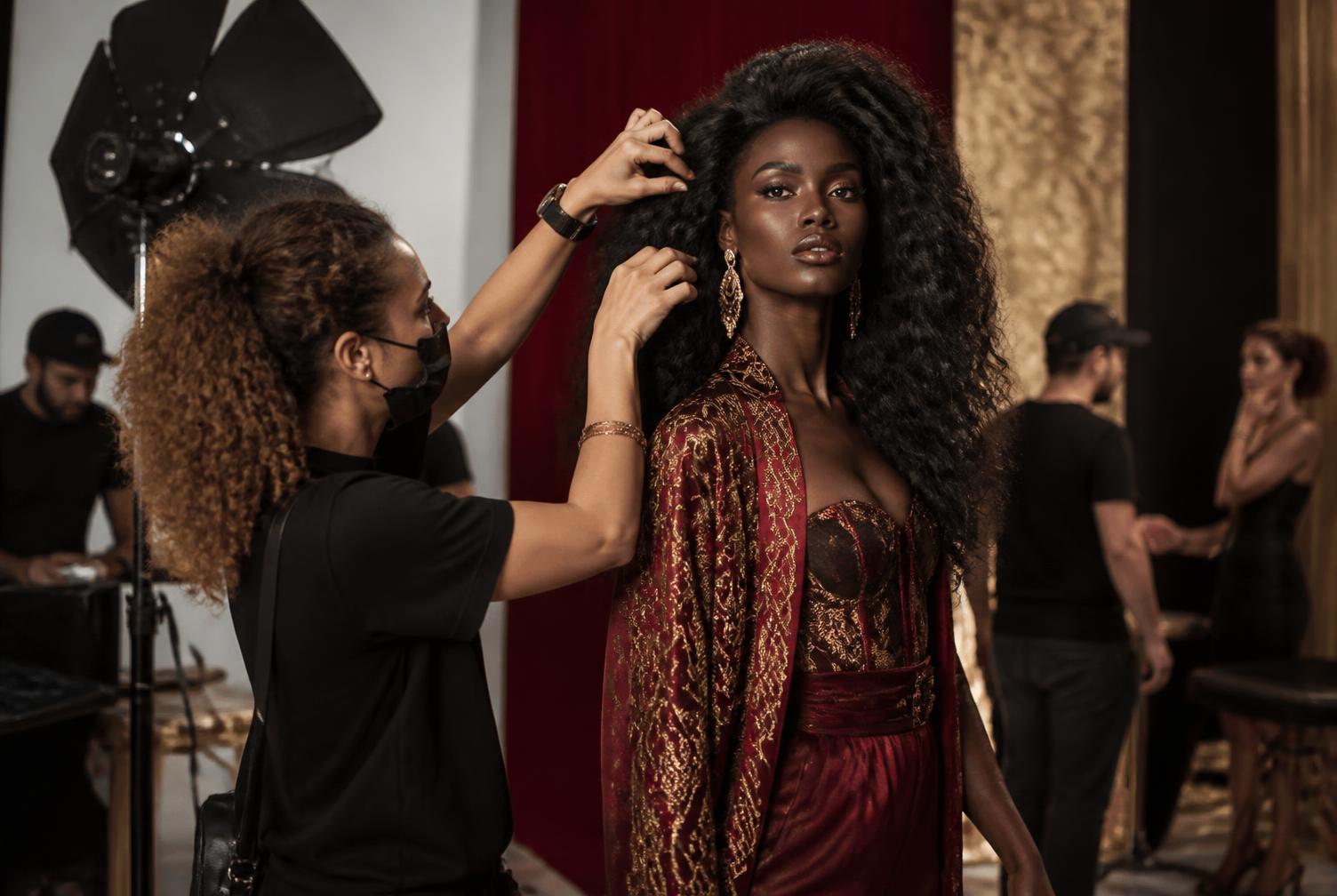 Stylist finishing a model's hair on a photo set